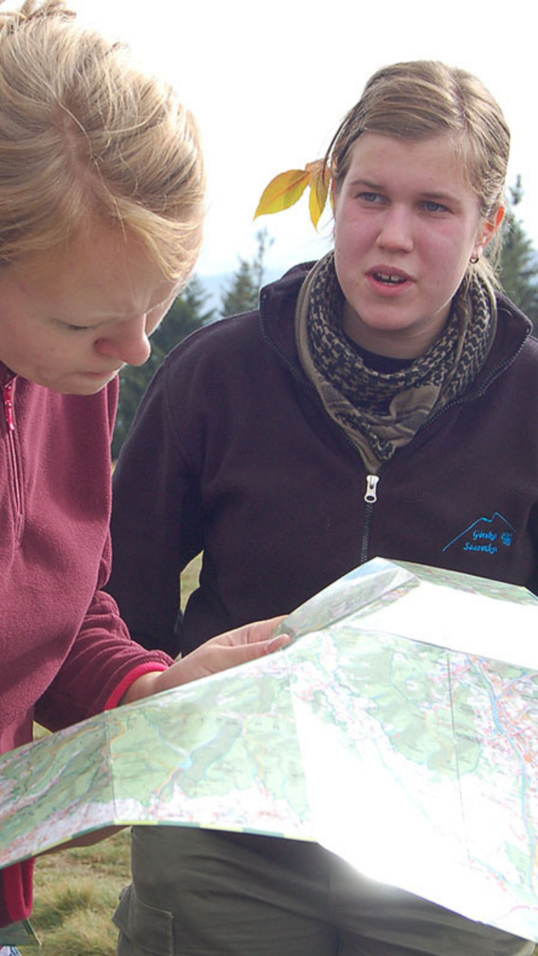 Zdjęcie przedstawia dwie dziewczyny wpatrujące się w mapę